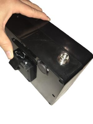 A person holding a black box with a button on it.