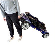 Person carrying folded mobility scooter